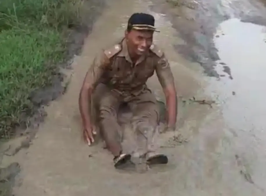 kades mandi lumpur di kubangan jalan yang rusak